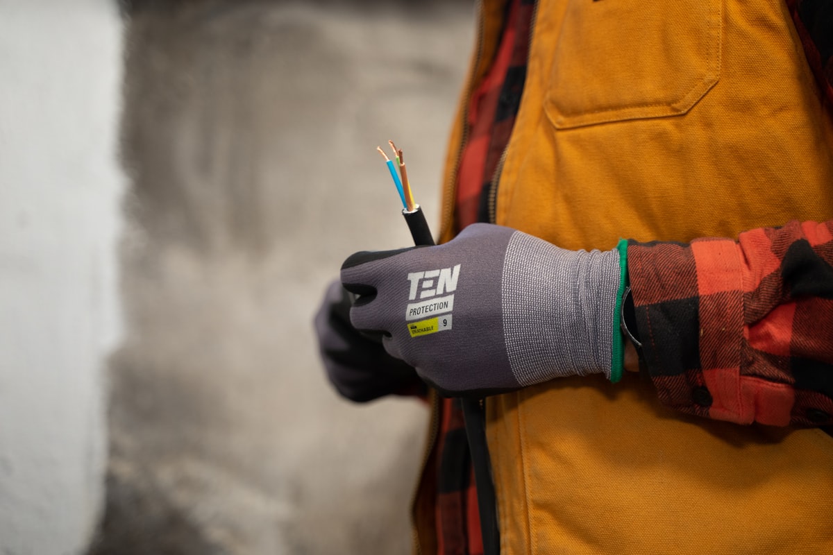 An electrician's hands working with electrical wires — the installation context where CITEL Type 1, Type 2, and Type 3 surge protective devices are wired into distribution boards to protect downstream equipment from lightning and switching overvoltages
