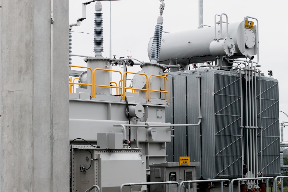 A power transformer with cooling radiators, conservator tank, and bushings at a substation - the tap-changed asset an automatic voltage regulator like the A.Eberle REG-DA keeps inside the voltage band