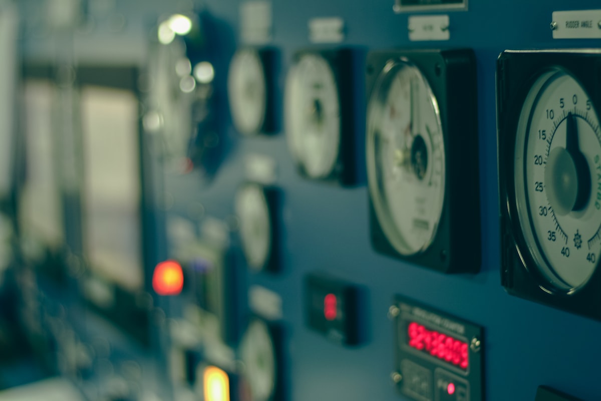 Analog moving-coil panel meters and a digital metering display side by side on an industrial switchboard - the two instrument families a Pakistani panel builder chooses between under IEC 60051 and IEC 62053