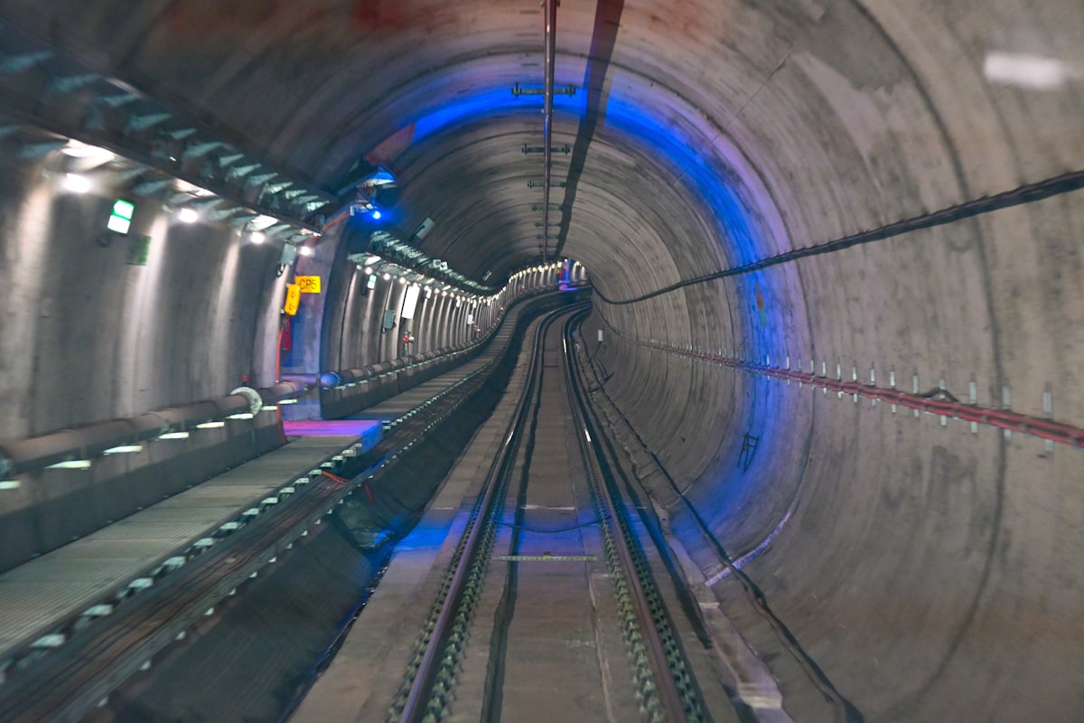 A modern metro tunnel with tracks and emergency walkway lighting - the environment where YTVOX weatherproof telephones, help points, and SIP intercom keep operators and passengers connected