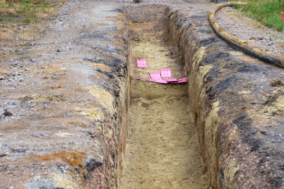 An open cable trench with sand bedding and marker tape - the dig spot that a disciplined IEEE 1234 fault-location sequence finds in metres, not guesses