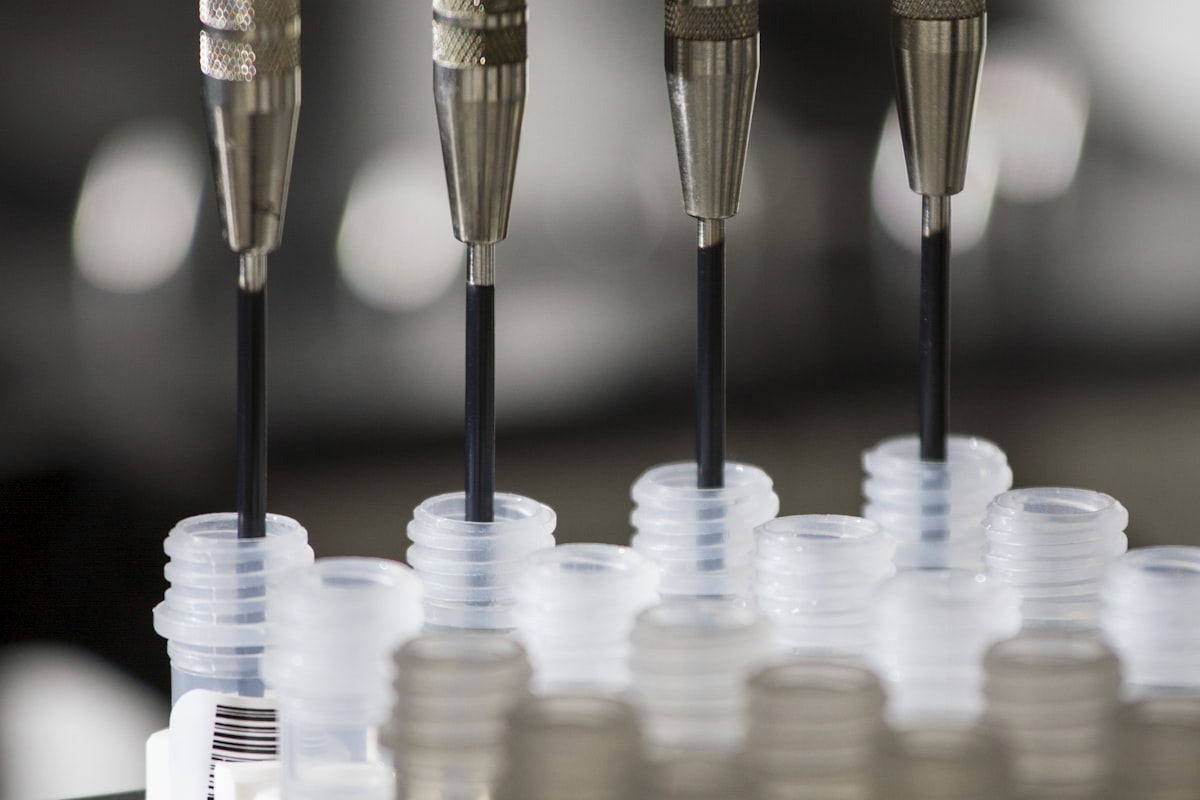 Laboratory dispensing needles filling a rack of sample vials - the sampling and analysis chain whose errors IEC 60567 exists to control before a DGA result is trusted as an alarm